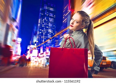 Beautiful Blonde Girl Holding A Red Shopping Bag In New York