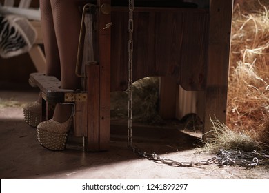 beautiful blonde girl in lingerie on chair for torture suffering in barn with hay