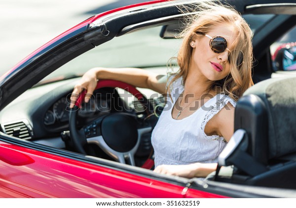 Beautiful blonde\
girl in a red convertible\
car