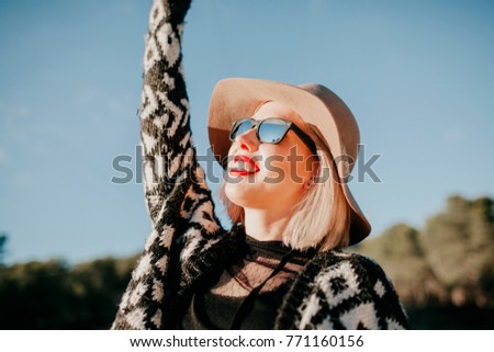 Similar – Blonde junge Frau mit Hut und Sonnenbrille, die bei Sonnenuntergang im Wald mit einem Mobiltelefon ein Foto macht.