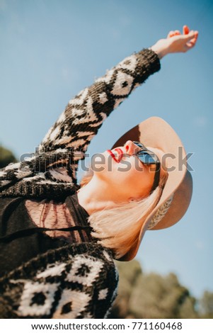 Foto Bild Junge blonde Frau mit Hut und Sonnenbrille genießt den Sonnenuntergang.