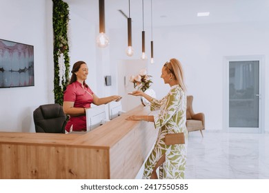 Beautiful blonde shakes hands with an employee of the dental office after the agreed dental examination - Powered by Shutterstock