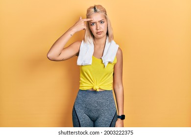 Beautiful Blonde Sports Woman Wearing Workout Outfit Pointing Unhappy To Pimple On Forehead, Ugly Infection Of Blackhead. Acne And Skin Problem 