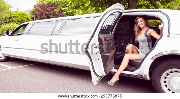 Beautiful\
blonde stepping out of limousine on a sunny\
day