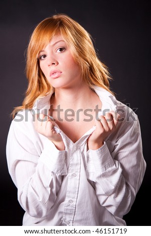 Beautiful blonde teen girl with white shirt on dark background