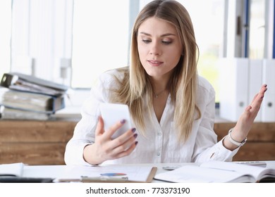 Beautiful blonde thoughtful businesswoman look at cellphone in hand portrait. White collar busy life style electronic device store online shop read text surprised amazed grimace concept - Shutterstock ID 773373190