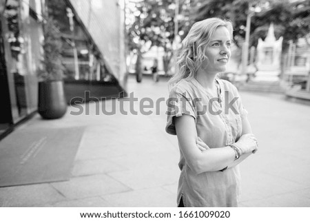 Similar – Young pretty woman in a pink blazer stands in front of an orange wall