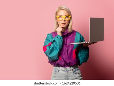 Beautiful Blonde Woman In 90s Clothes With Laptop Computer On Pink Background
