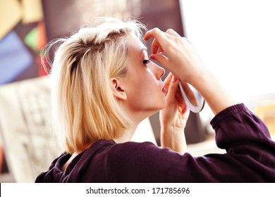 Beautiful Blonde Woman Applying False Lashes To Herself