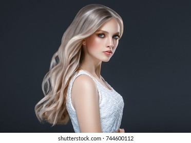 Beautiful Blonde Woman Beauty Model Girl with perfect makeup and hairstyle over black background.