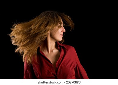 Beautiful blonde woman flipping her hair, isolated on black background