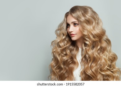 Beautiful blonde woman hair model with long blond healthy curly hairstyle on white background