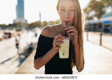 Beautiful Blonde Woman Having A Fresh Drink Outdoors In Summer