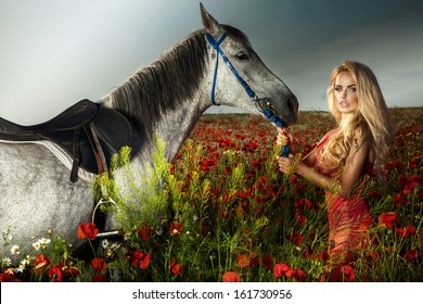 Beautiful blonde woman with long curly hair posing with horse.