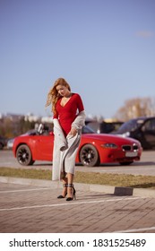 Beautiful Blonde Woman In A Red Dress Posing In A Red Car 