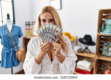 Beautiful Blonde Woman At Retail Boutique Holding Dollars Banknotes Skeptic And Nervous, Frowning Upset Because Of Problem. Negative Person. 