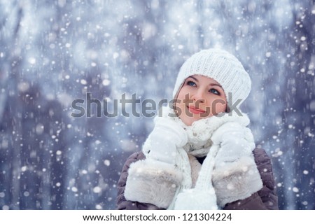 beautiful blonde woman walking outdoors under snowfall
