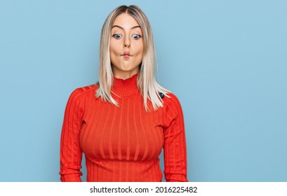 Beautiful Blonde Woman Wearing Casual Clothes Making Fish Face With Lips, Crazy And Comical Gesture. Funny Expression. 