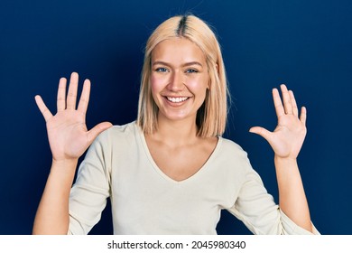 Beautiful blonde woman wearing casual sweater showing and pointing up with fingers number ten while smiling confident and happy. 