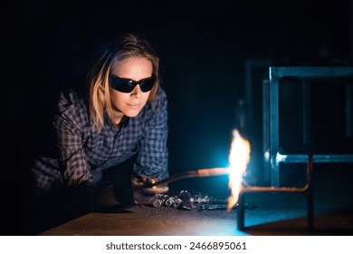 Beautiful blonde woman works as a welder in workshop, operating welding machine, wearing safety goggles for eye protection. - Powered by Shutterstock