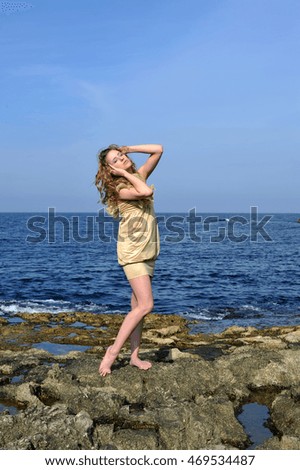 Young woman standing with closed eyes at the Baltic Sea beach