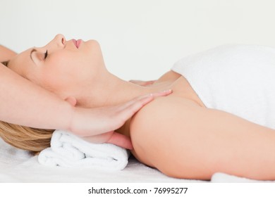 Beautiful blond-haired woman lying down while receiving a spa treatment