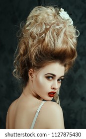 Beautiful blondie girl is sexually posing with  a Middle Ages historical hairstyle