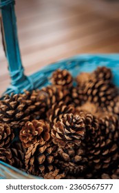beautiful blue basket with pine cones on wooden table, very decorative and used in autumn, winter and Christmas