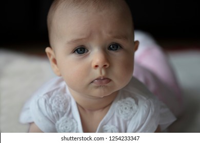 Beautiful Blue Eyed Baby Girl Drooling. Looks Very Serious