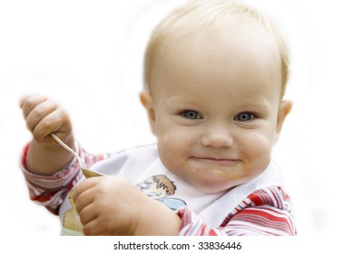 Beautiful Blue Eyed Blond  Baby Eating Apple Sauce With A Spoon Isolated In White