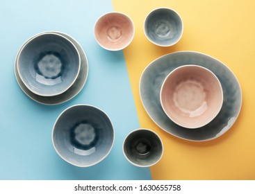 Beautiful blue, grey, beige dinnerware, plates bowls on lilac table, top view, toned, selective focus
