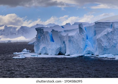 Beautiful Blue Ice Cliffs And Blue Ice Crevasses Of A Tabular Blue Iceberg From A Melting Tidewater Glacier Floating Off The Stunning Antarctic Scenery Of The Antarctic Peninsula Of Polar Antarctica