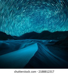 Beautiful Blue Night Desert And Dune On Star Trail Background.