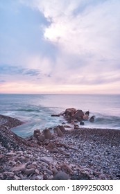 Beautiful Blue Pink Purple Sunset Sky Over Sea Coast With Pebble Beach. River Flows Into Sea, Long Exposure. Beautiful Sea Landscape.