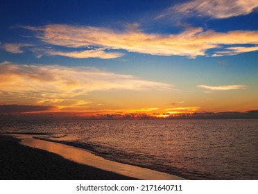 Beautiful blue red golden sunset. Colorful dawn over the sea. Nature beauty. Enjoying the sundown with cloudy sky on the beach.