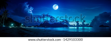 Beautiful blue sky with cloud and bright full moon on seascape at night. Serenity background, outdoors at nighttime. The moon taken with my own camera.