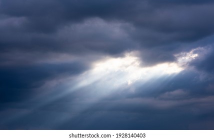 Beautiful Blue Sky And Dark Clouds With Dramatic Light In The Evening Before Sunset Light Penetrates Through The Clouds, Causing The Beam, Twilight Sky Background.