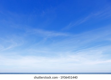 Beautiful Blue Sky Over The Sea With Translucent, White, Cirrus Clouds. The Horizon Line