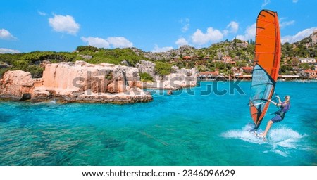 Beautiful blue sky with Windsurfer Surfing Wind On Waves - Sunken Lycian City On Kekova Island - Clear turquoise sea of Kekova bay - Kekova, Turkey