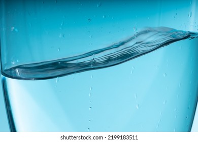 Beautiful Blue Splash Of Water In A Glass Vessel. Clean Clear Water. High Quality Photo