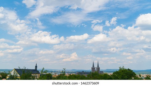 Beautiful Blue Summer Sky With Bright Clouds And A Old Medieval Town In A Rural Landscape