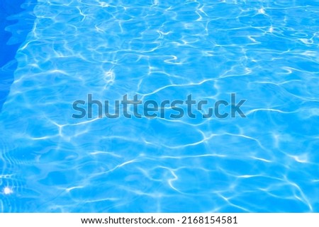 Beautiful blue texture of water. The waves shimmer in the sun. Relax by the pool in summer