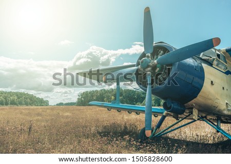 Beautiful blue and yellow airplane on a forest and sky background. Vintage aircraft.