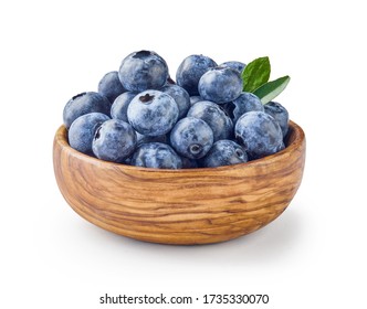 Beautiful blueberries with blueberry leaves in wooden bowl isolated on white background.