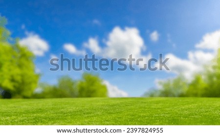 Beautiful blurred background image of spring nature with surrounded by trees against a blue sky with clouds on a bright sunny day.