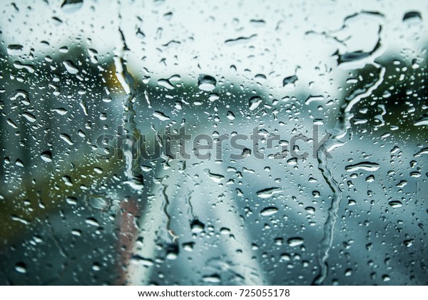 Beautiful\
blurred view front of a auto glass car,Close up heavy rain and\
water drops on surface of auto glass car texture and background on\
the street or road for design and\
architect