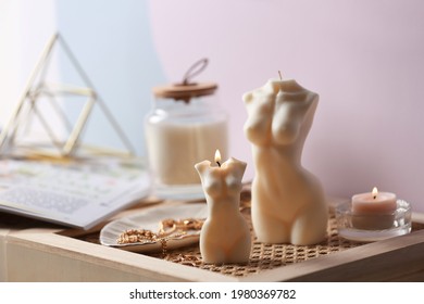 Beautiful body shaped candles and jewelry on tray indoors
