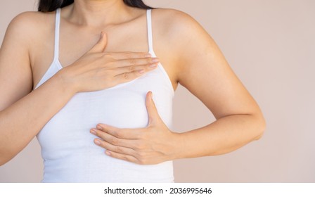 Beautiful body of young Asian woman on camisole touch breast by hand to check cancer or diagnose chest disease and beauty massage as female health care awareness and medication for skin augmentation