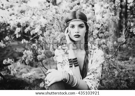 Beautiful bohemian girl in spring garden. Black and white photo of woman. Monochrome colors