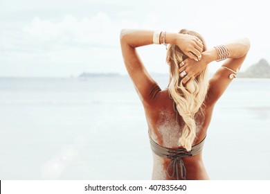 Beautiful bohemian styled and tanned girl at the beach in sunlight - Shutterstock ID 407835640